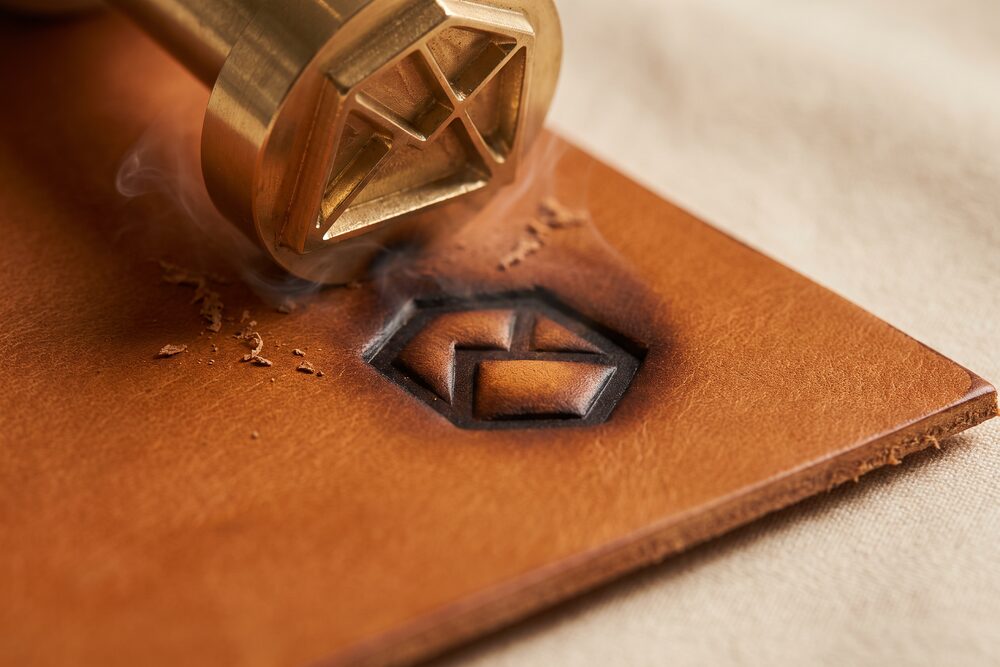 A shape pressed down into tan leather, shadow pooling in the recess